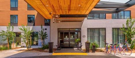 Un edificio moderno con techo de madera y un área de acceso empaveda.