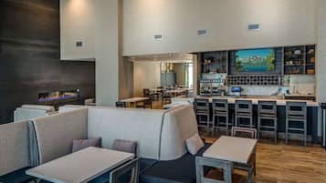A modern restaurant with high tables, booths, and a bar area.