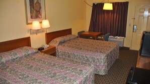 A hotel room with two beds, a desk, a chair, a lamp, and a television. - America's Best Inn and Suites Beaufort (Beaufort)