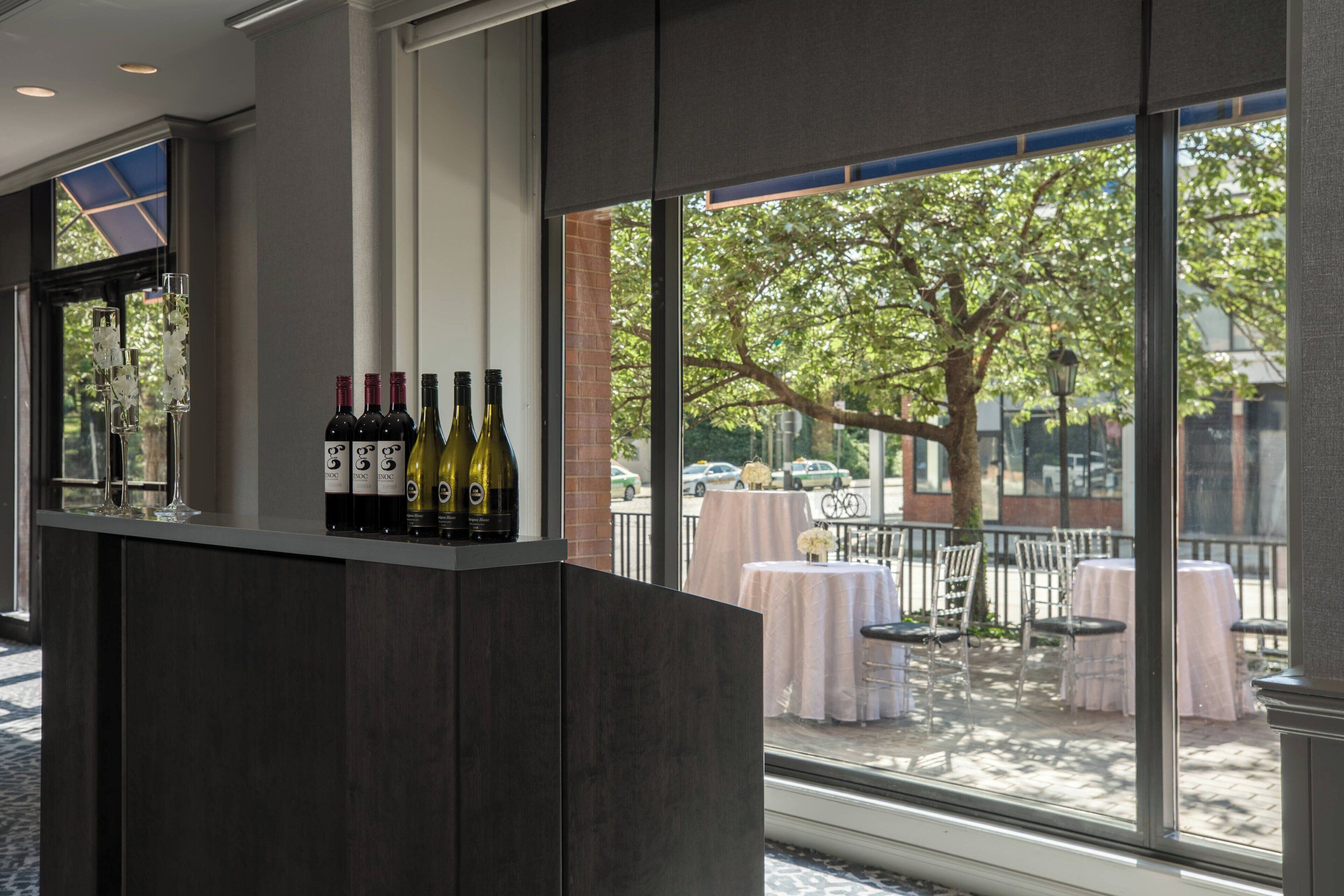Zona de bar con botellas de vino y vistas a una terraza.