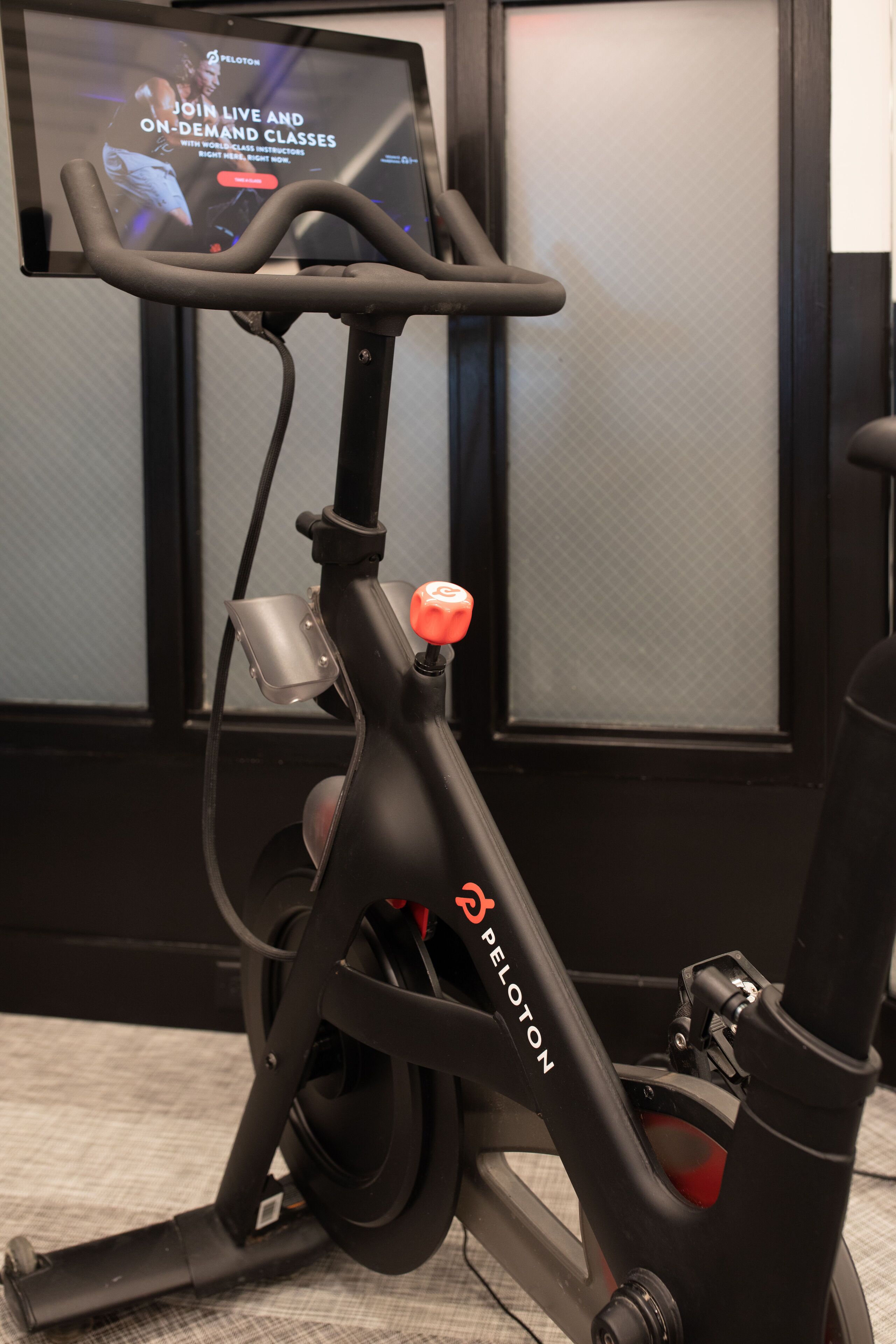 Una bicicleta estática con una pantalla que muestra un anuncio de Peloton.