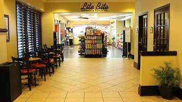 A Lite Bite Convenience Store & Deli with a tiled floor, seating area with tables and chairs, and a display of snacks and beverages.