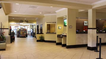 A hotel lobby with a business center, a convenience store, and a reception desk.