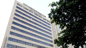 Un hotel moderno de gran altura con varios pisos y un cartel llamativo en la parte superior.