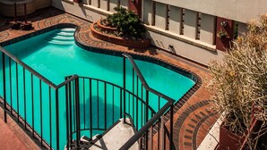 Una piscina en la azotea con vistas despejadas al mar y un paisaje urbano distante.