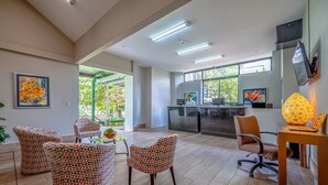 A modern office space with patterned chairs, a reception desk, and artwork on the walls.