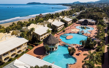 A resort with multiple swimming pools, a beach, and ocean views.