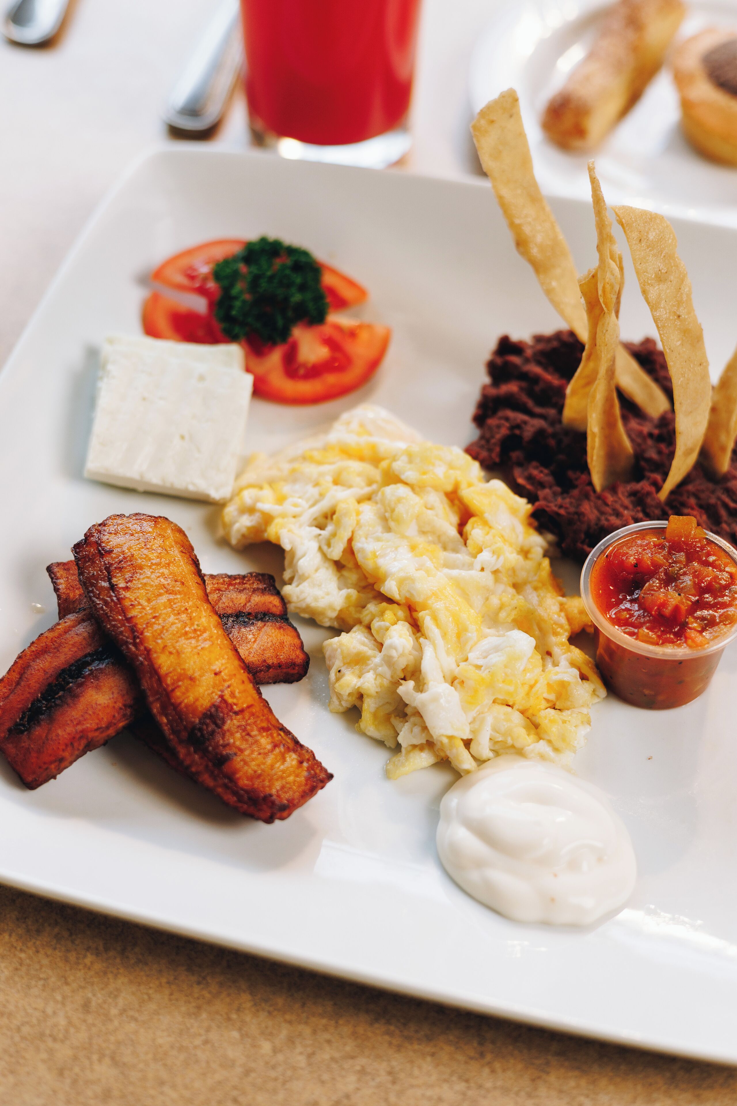 A breakfast plate with eggs, bacon, toast, and a cup of coffee.