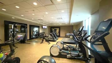 A gym with treadmills, elliptical machines, and weight equipment.