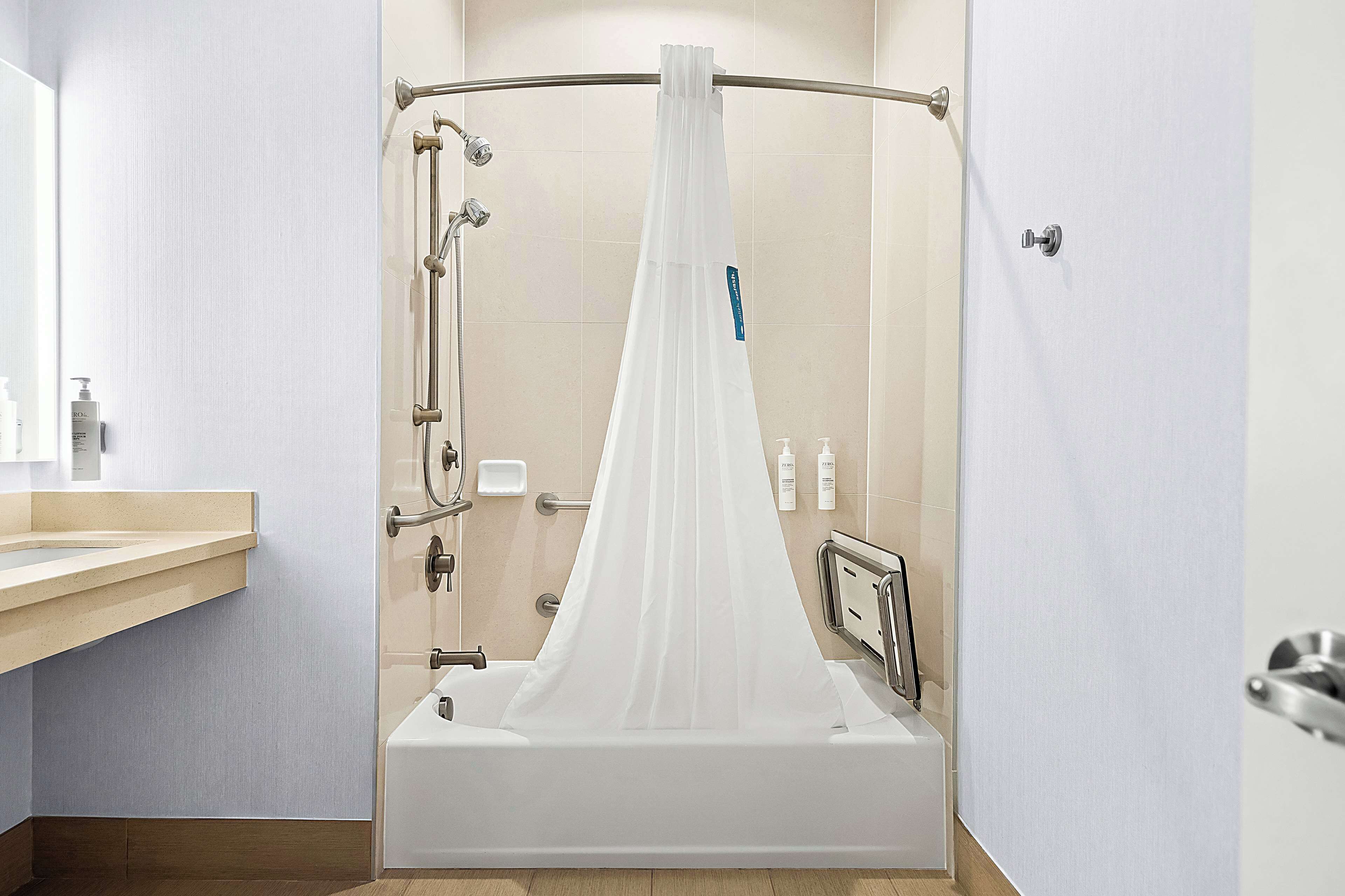A modern bathroom with a walk-in shower, a bathtub, and a vanity with a mirror.