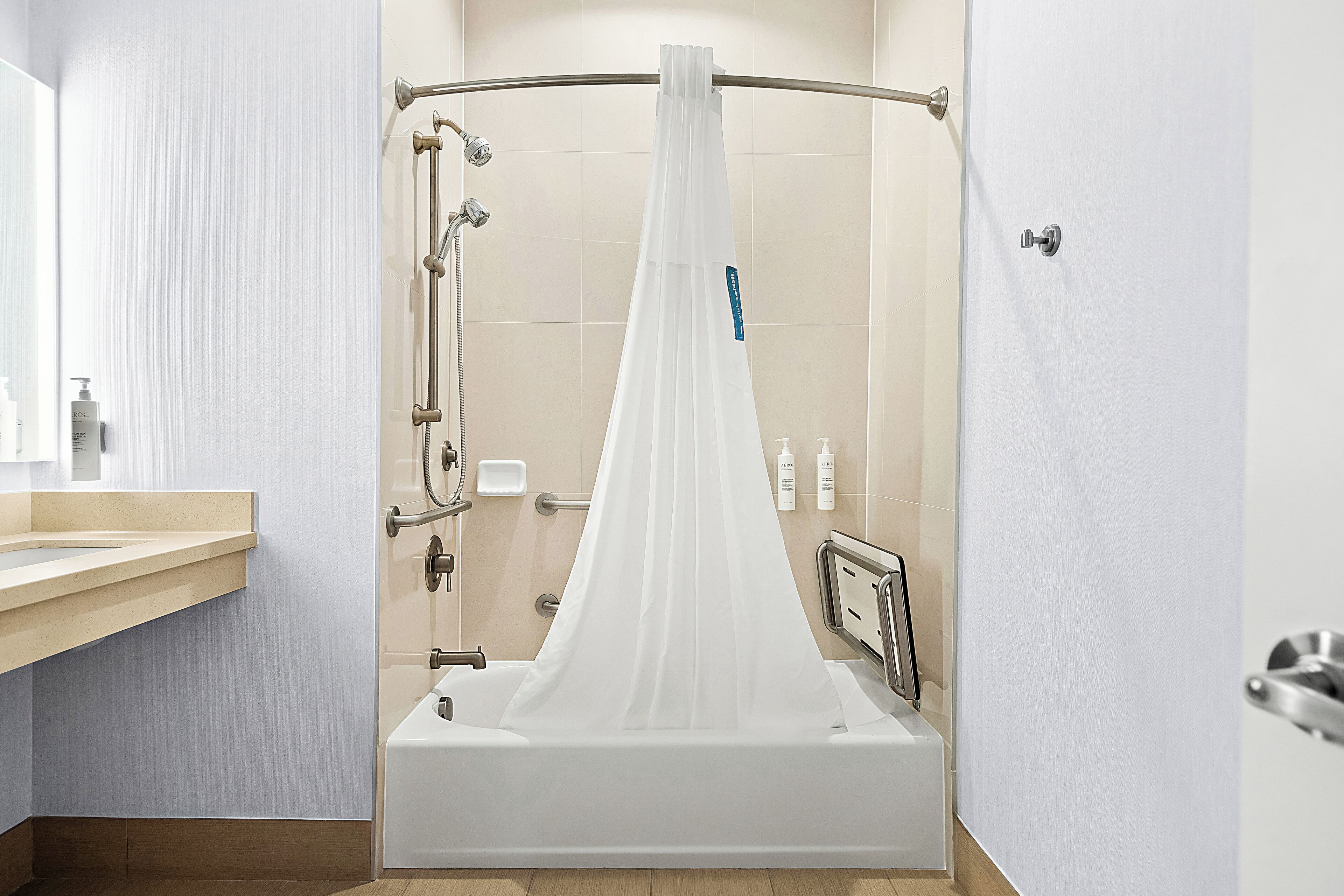 Une salle de bain moderne avec une douche à parois de verre, un meuble-lavabo en bois et un miroir.