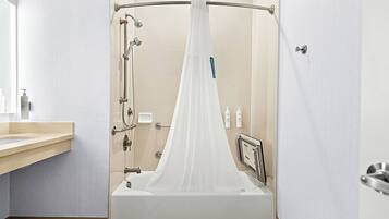 A modern bathroom with a glass-enclosed shower, a wooden vanity, and a mirror.
