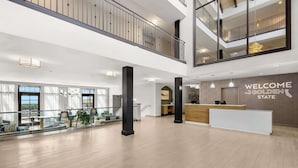 A spacious lobby with a reception desk, a staircase, and a view of the outdoors. - Hampton Inn Morgan Hill (Morgan Hill)
