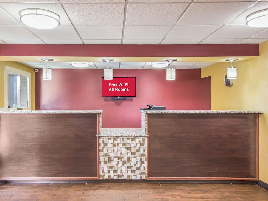 A reception area with a 'Free Wi-Fi All Rooms' sign, a reception desk, and a tiled floor.