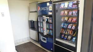 Un espace comprenant un distributeur automatique et un réfrigérateur à boissons de la marque Pepsi, ainsi qu’un autre distributeur automatique de collations.
