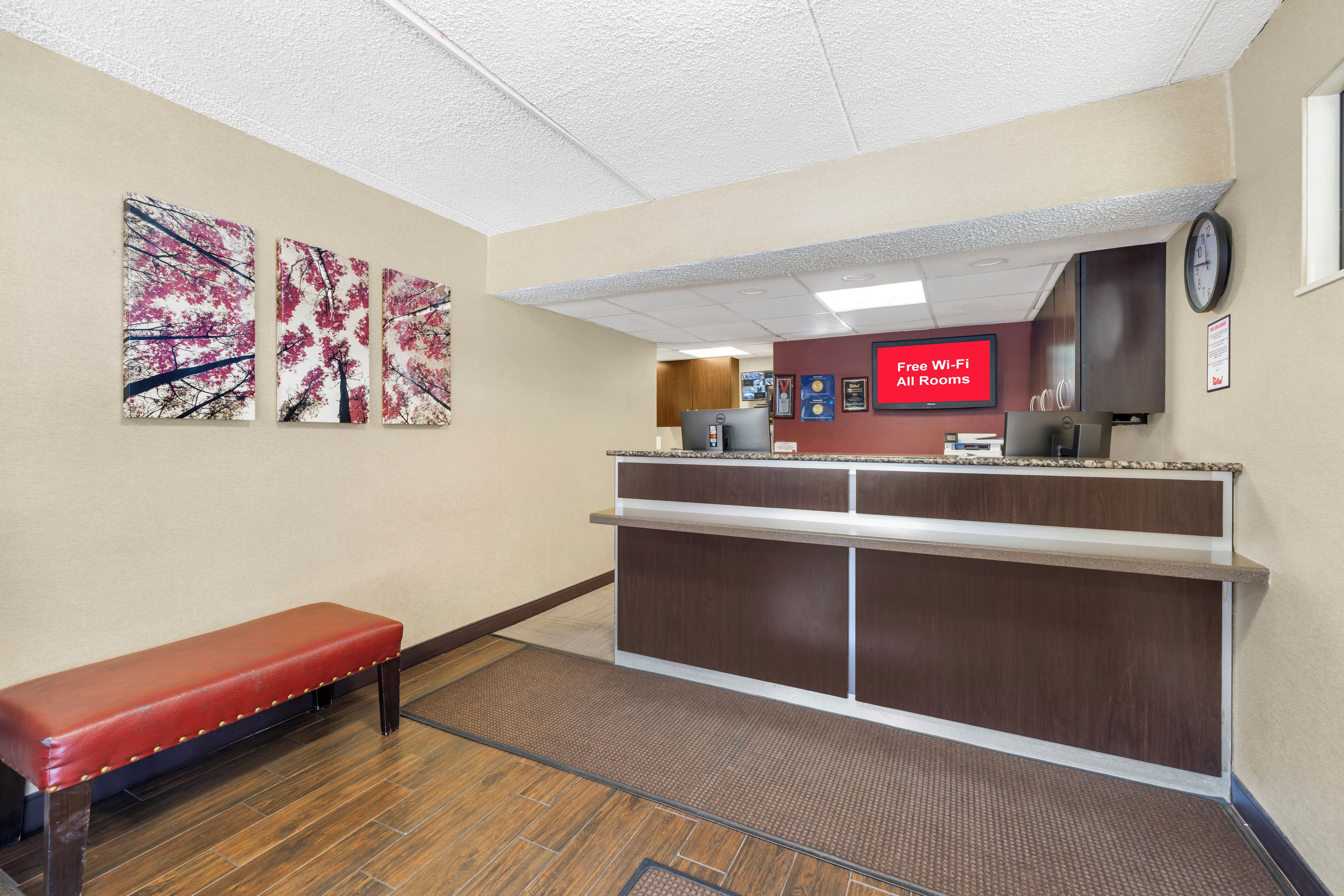 A reception area with a bench, a counter, and artwork on the wall.