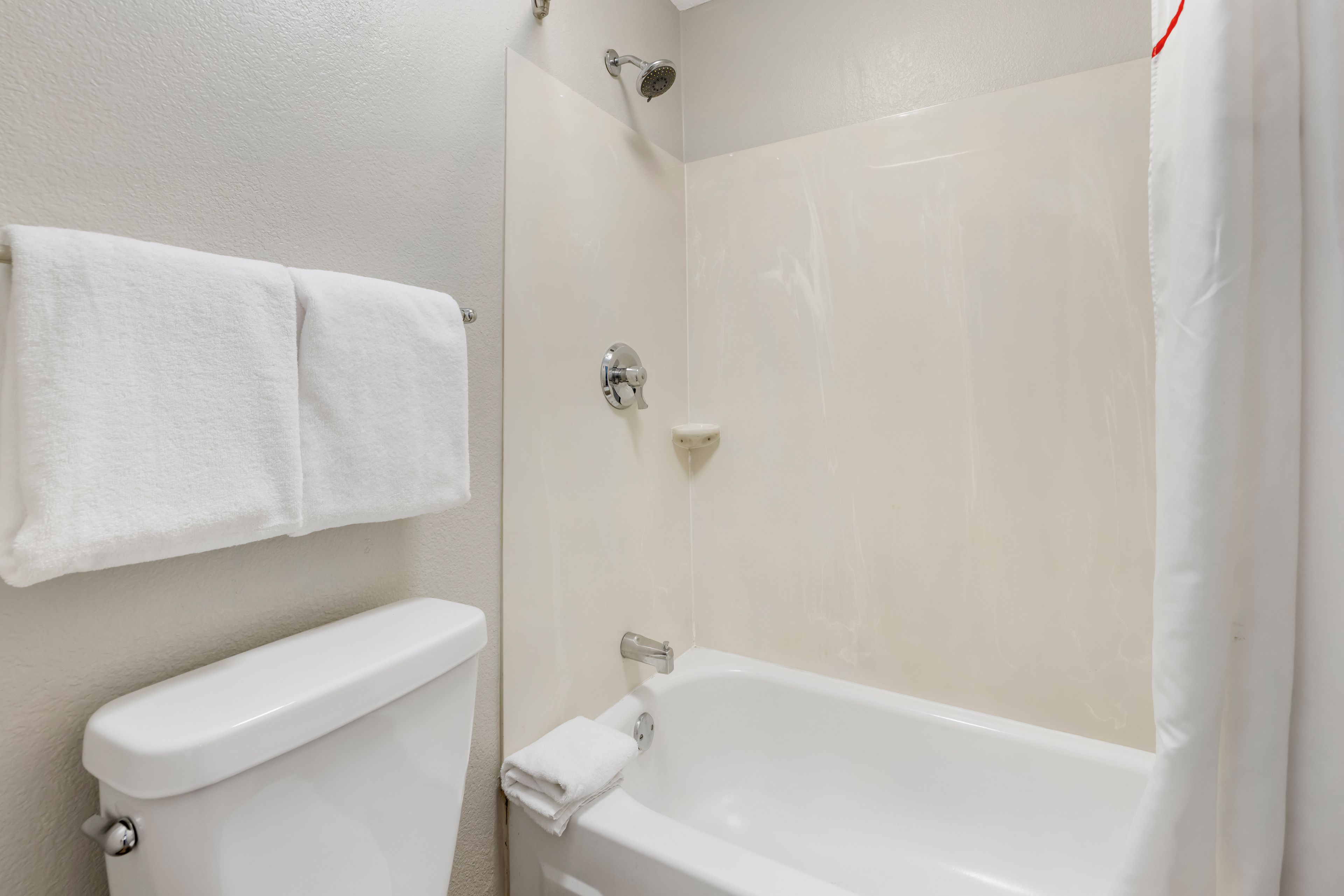 A bathroom with a toilet, a bathtub, and a shower.