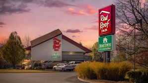 Un hôtel Red Roof Inn avec un grand bâtiment et une enseigne indiquant « HomeTowne Studios ».