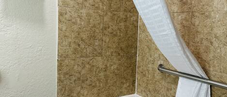 A bathroom with a bathtub, a shower curtain, and a towel rack.