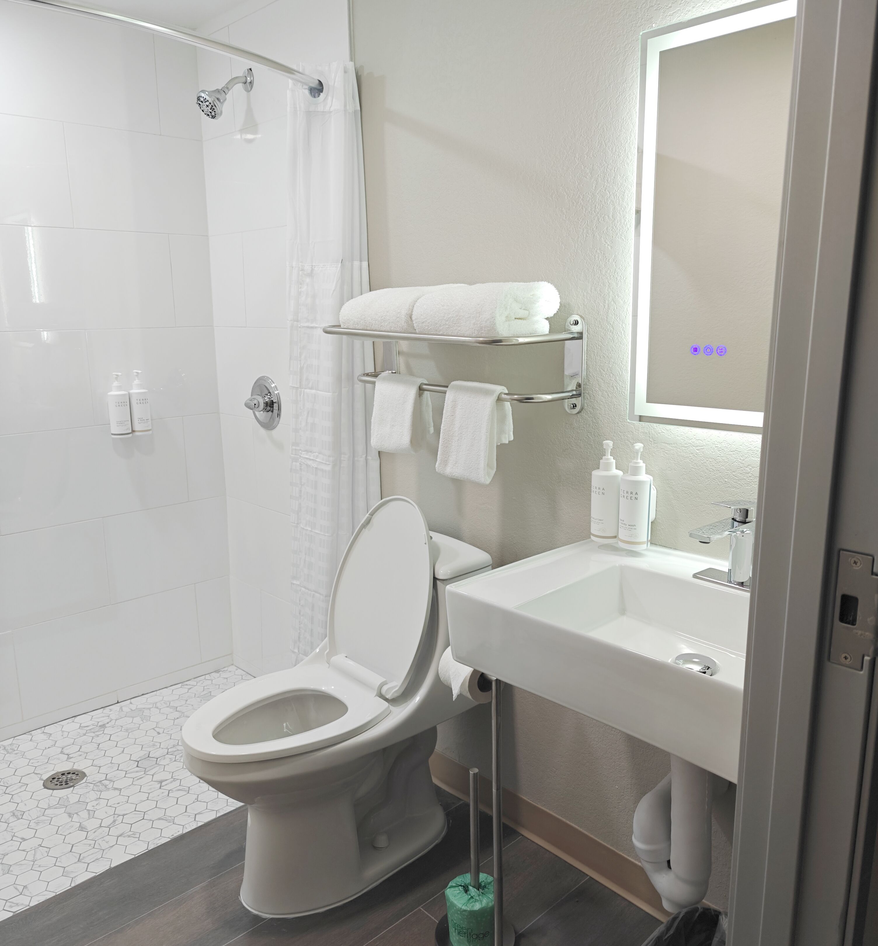 Un baño moderno con inodoro, ducha y lavamanos.