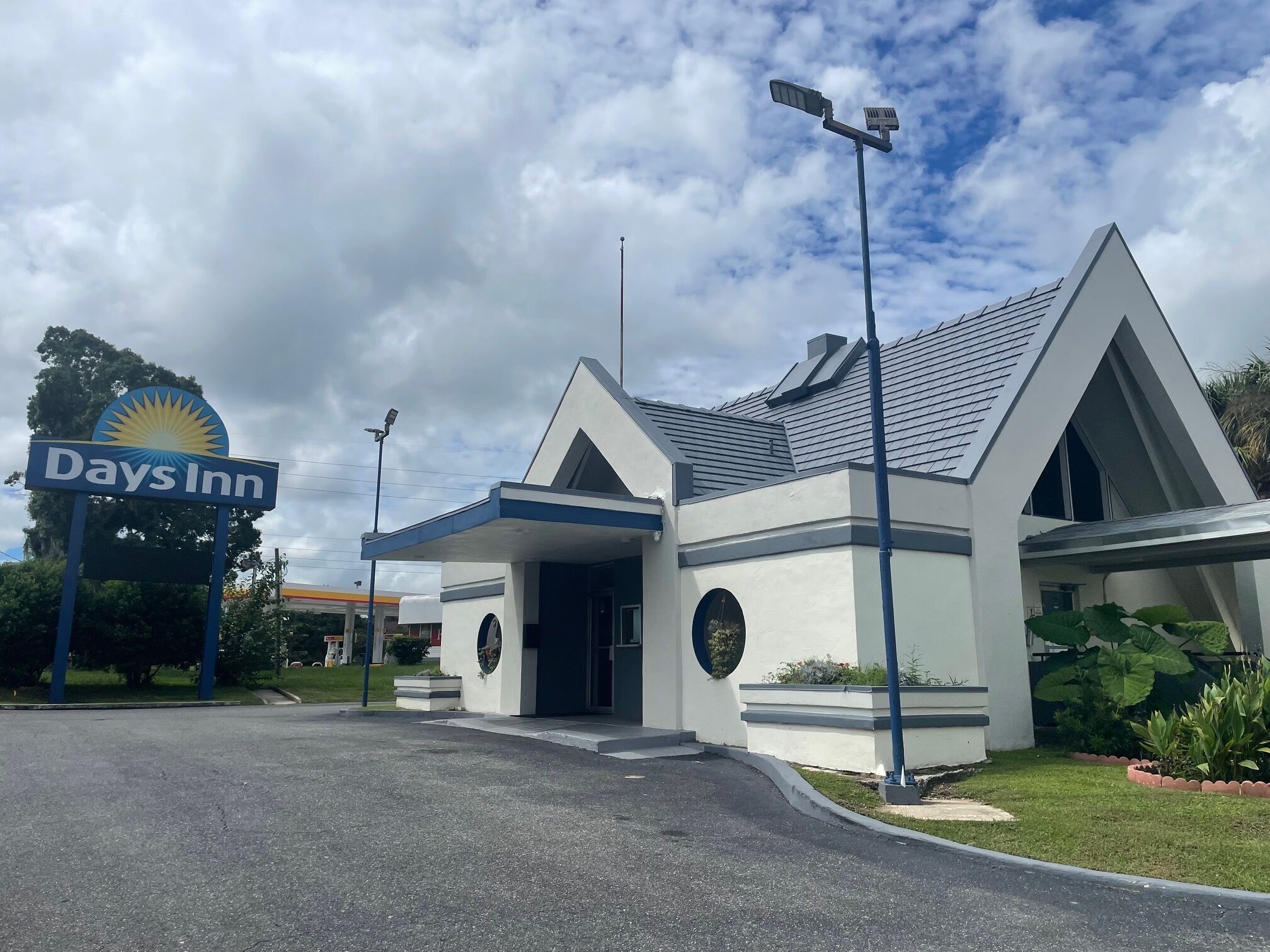 A Days Inn hotel with a modern design, featuring a prominent sign, a covered entrance, and a landscaped front yard.