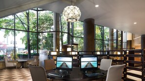 Una sala de conferencias moderna con ventanas amplias, múltiples monitores y una mesa central.