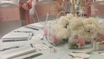 A table set for a formal event with clear name cards, silverware, and floral centerpieces.