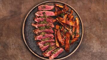 A plate of food with steak and roasted potatoes.