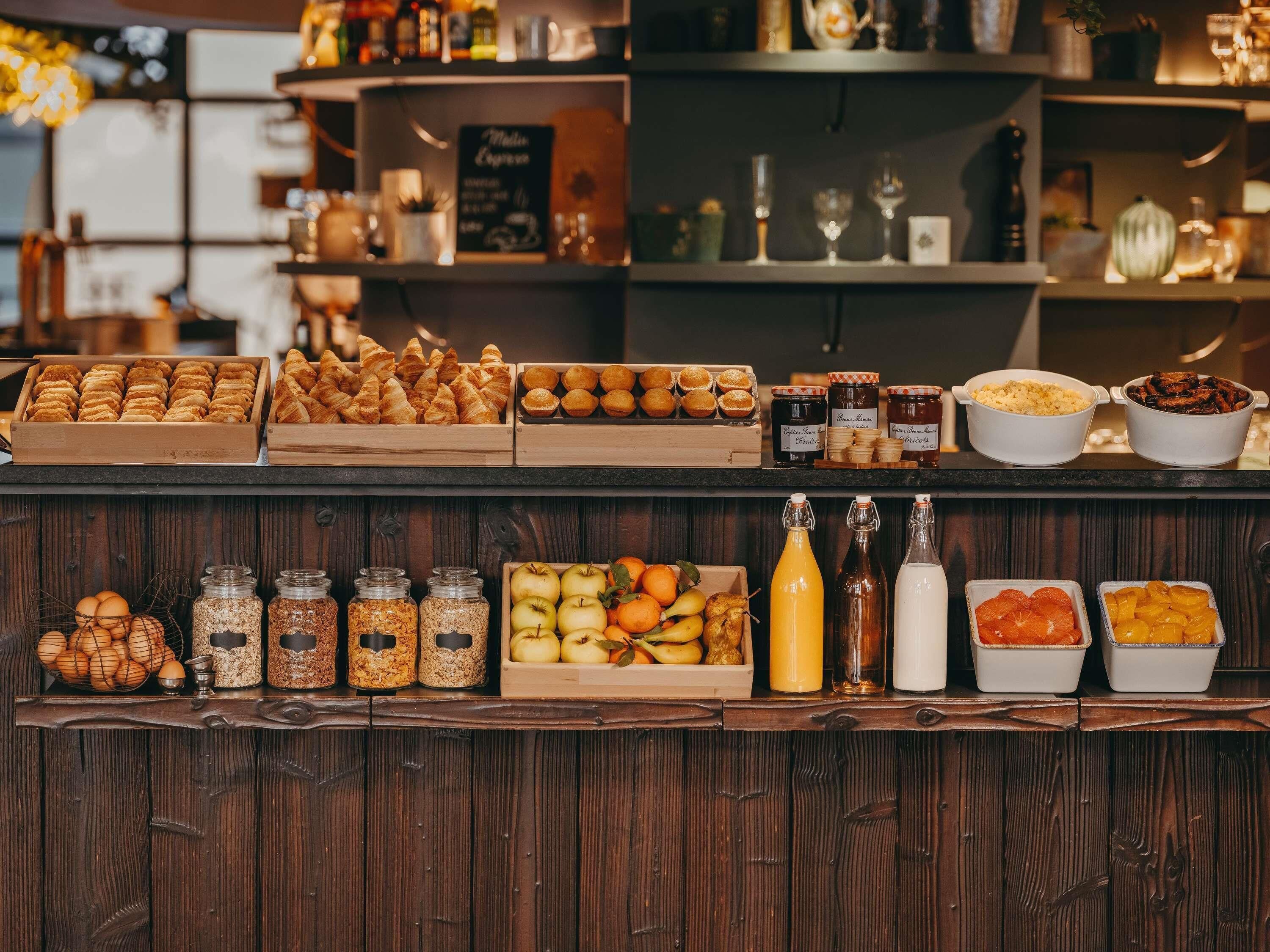 A breakfast buffet with pastries, fruits, and beverages.