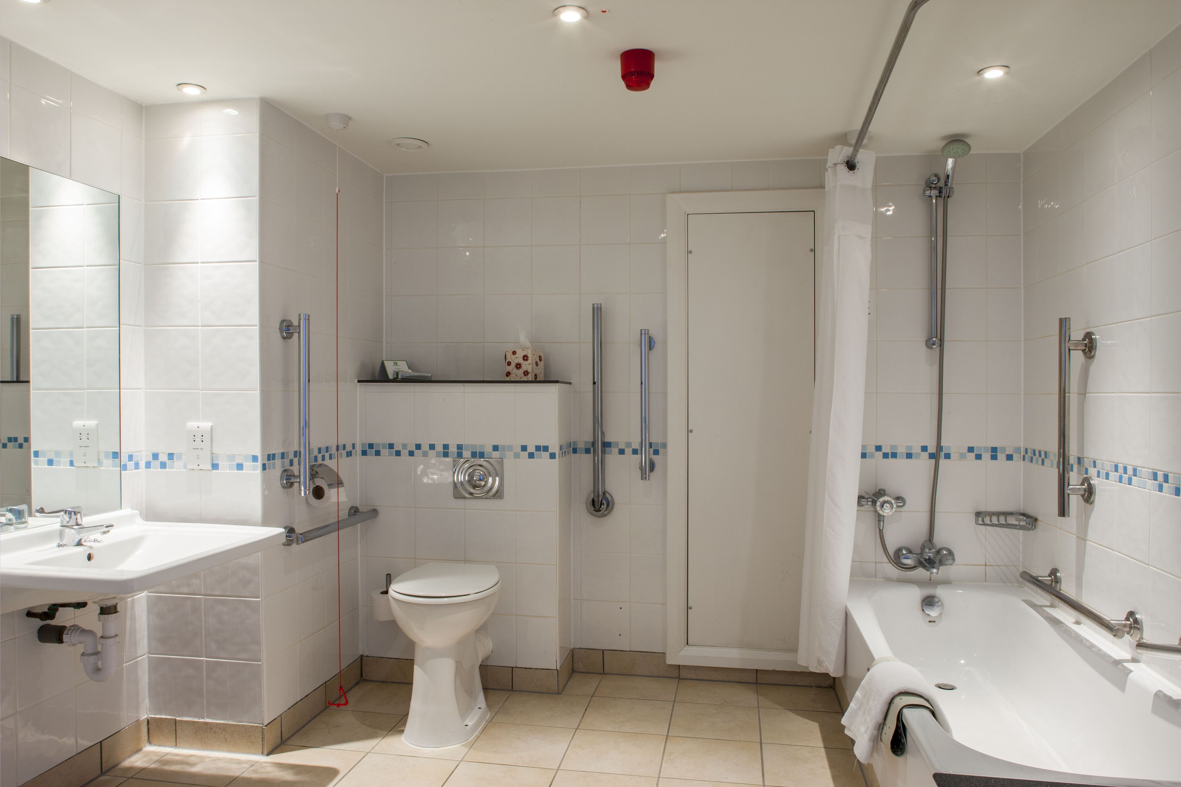 A modern bathroom with a sink, toilet, shower, and bathtub.