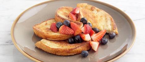 Ein Teller Französisch Toast mit Erdbeeren und Blaubeeren.