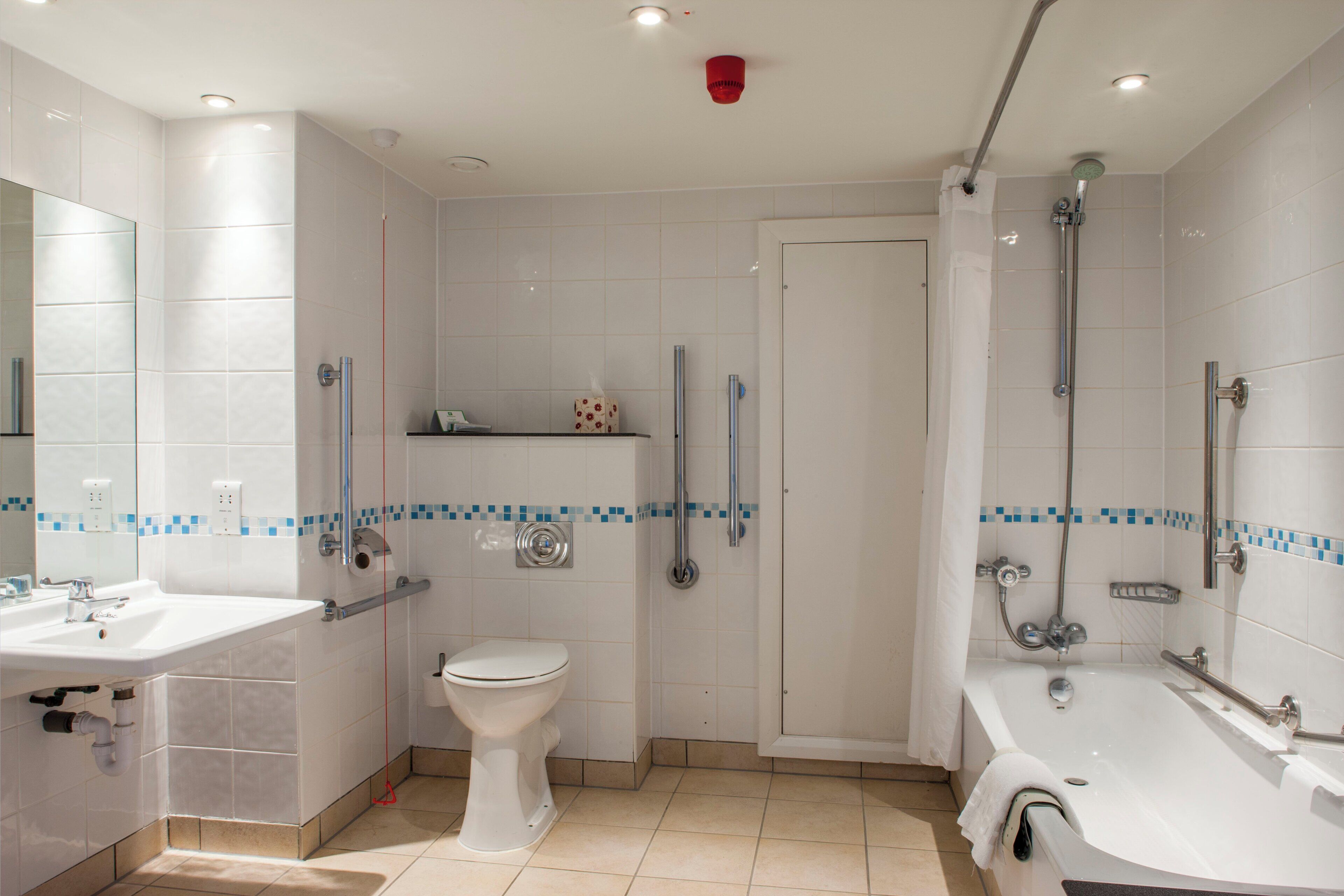 A modern bathroom with a bathtub, a toilet, and a shower area.
