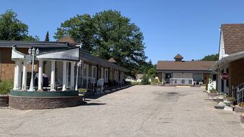 A building with a covered porch, a stop sign, and a gravel driveway.