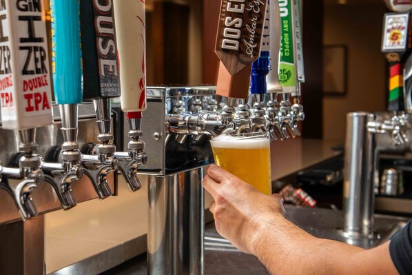 A bar with multiple beer taps, including brands like GIN ZER and DOSE 5.