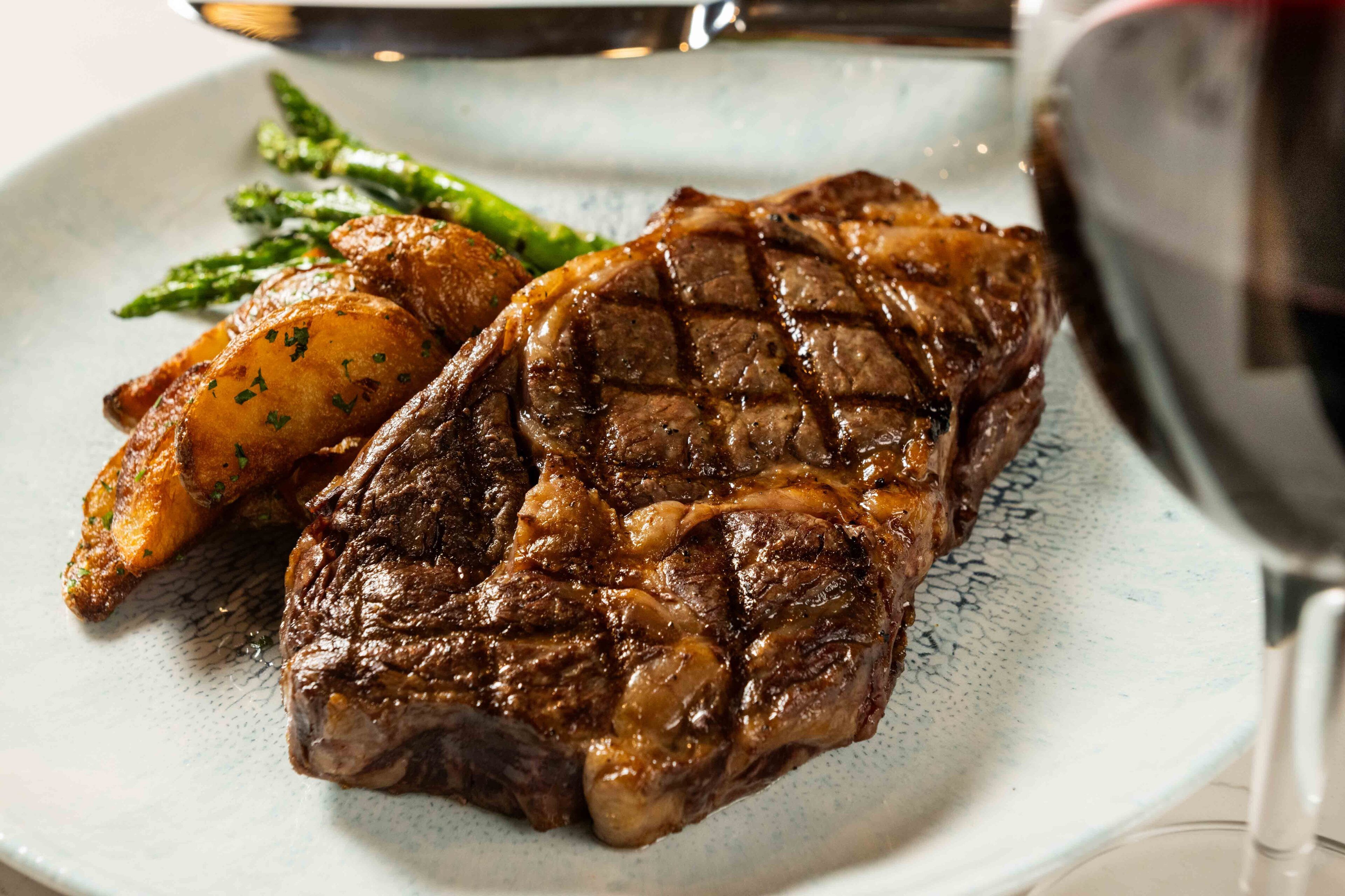 A plate with a grilled steak, roasted potatoes, and asparagus.