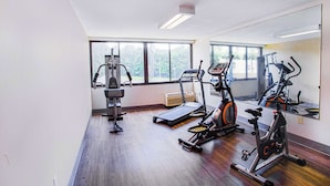 A gym with cardio machines, a treadmill, and a stationary bike.