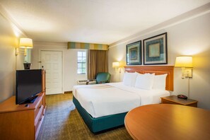Una habitación de hotel con cama, televisión, escritorio y silla.