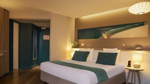 A modern hotel room with a large bed, a bedside table with a lamp, and a wall-mounted artwork. - Hôtel Le B d’Arcachon by Inwood Hotels (Arcachon)