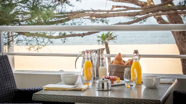 A breakfast setup on a balcony with a view of the beach. - Hôtel Le B d’Arcachon by Inwood Hotels (Arcachon)