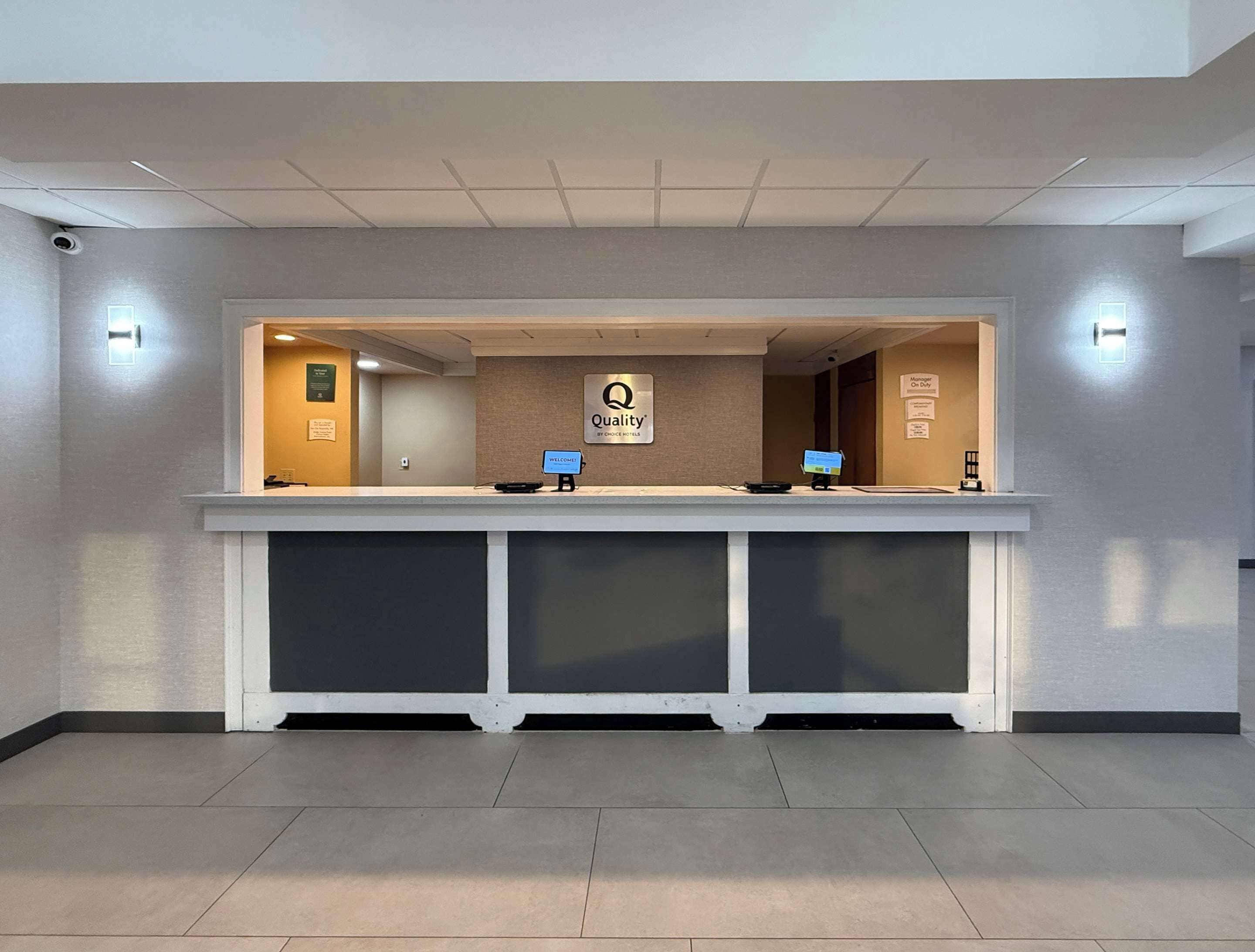 Un mostrador de recepción de hotel con un letrero que dice 'Quality by Choice Hotel'.