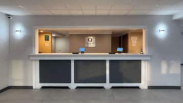 Un mostrador de recepción de hotel con un letrero que dice 'Quality by Choice Hotel'.