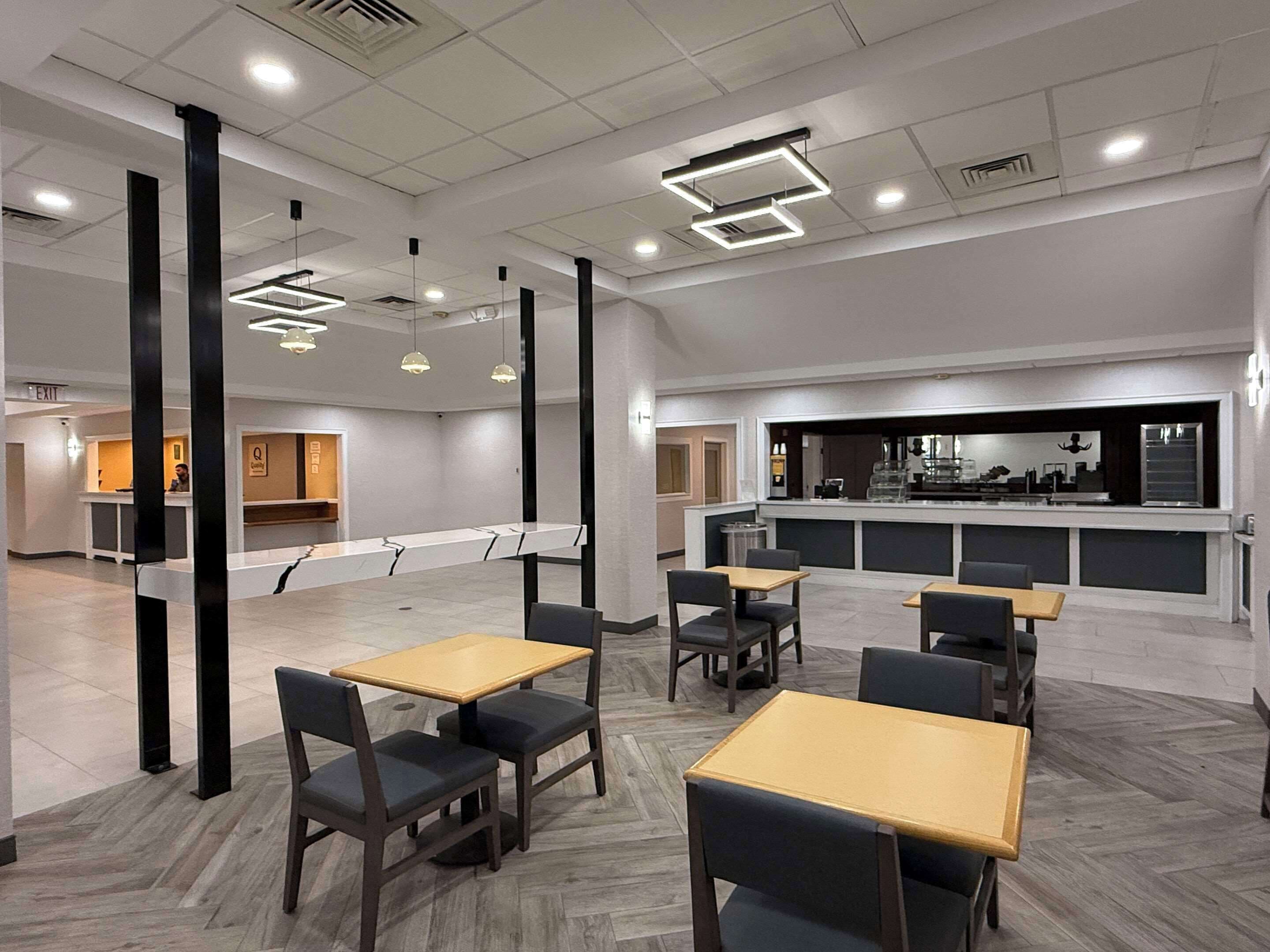 Un hall d’hôtel moderne comprenant un comptoir d’accueil, un espace salon et un bar.