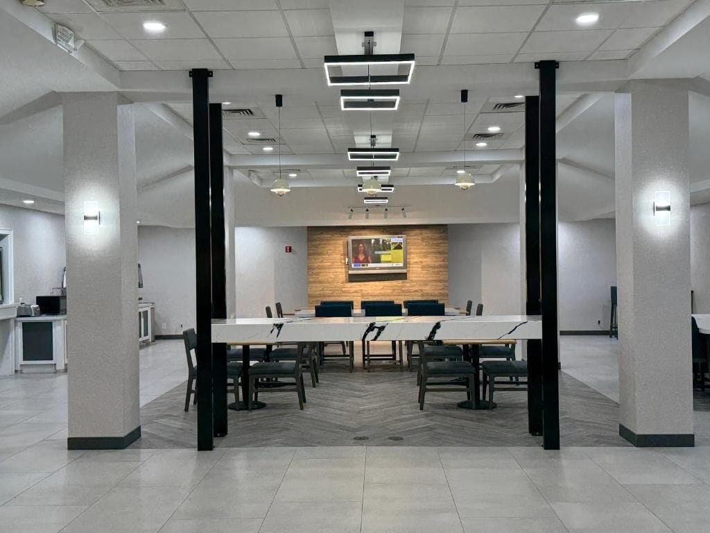 A conference room with a long table, chairs, and a wooden accent wall.