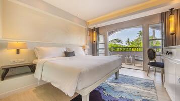 Quarto de hotel moderno com uma cama grande, mesas de cabeceira, uma escrivaninha e vista para o exterior.