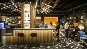 Eine moderne Bar mit einer Holztresore, Barhocker und einem gemusterten Boden.