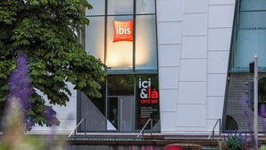 Ein Gebäude mit einem Schild für 'ibis Hotels' und einem weiteren Schild für 'ici & la Coffee Shop', wobei die Schriftzüge auf Französisch sind.