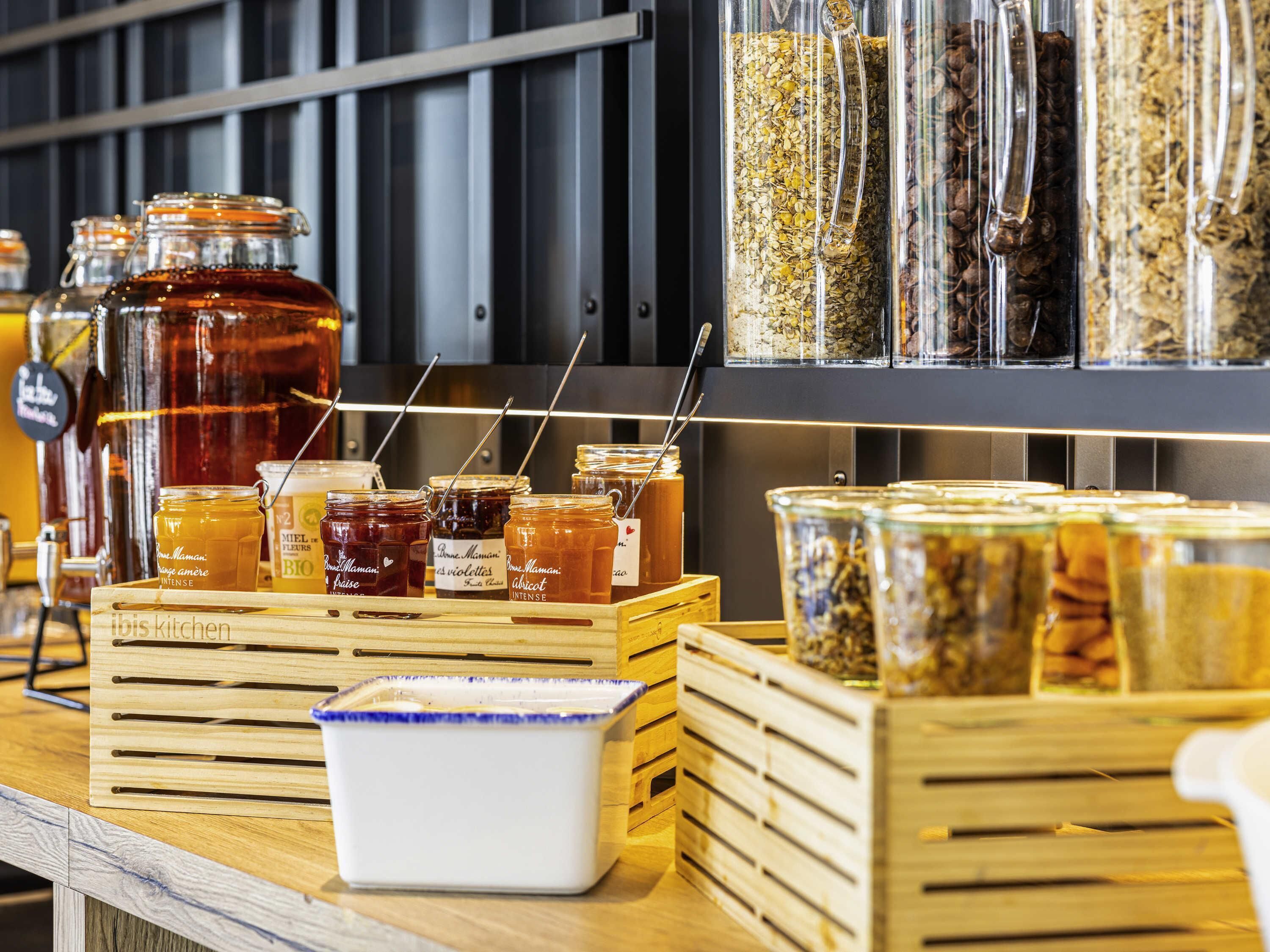 A display of honey jars and jars of spices on a wooden counter.