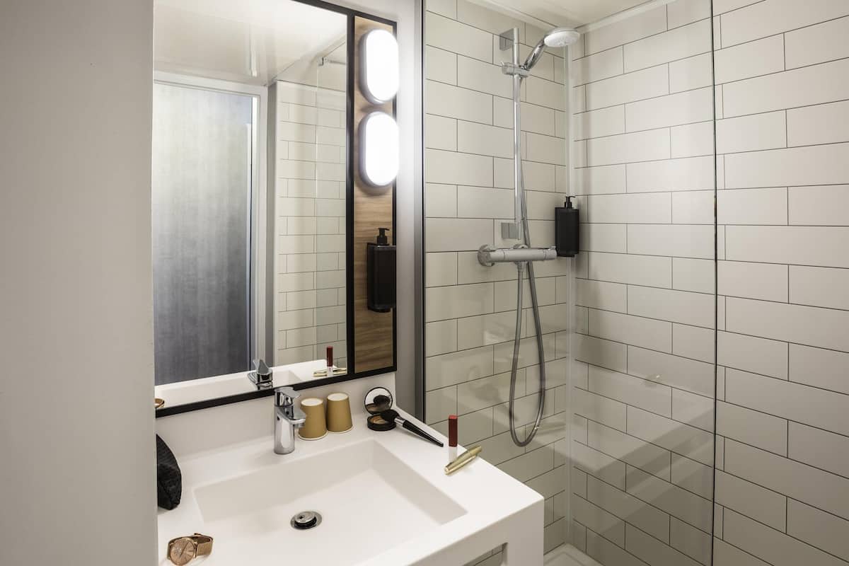 Ein Badezimmer mit Waschbecken, Spiegel und Dusche.