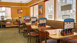 Un interior de restaurante con cabinas y mesas, pizarras con el menú y una estación de café.