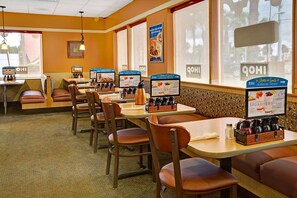 Enjoy a meal in a cozy booth with a table and menu stand.
